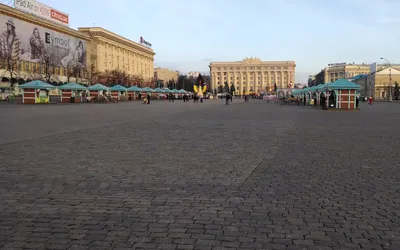 Brukowany Plac Swobody w Charkowie z budkami jarmarcznymi i monumentalnymi gmachami w tle