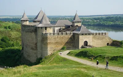 Kamienne mury i baszty twierdzy w Chocimiu nad Dniestrem, turyści na brukowanej drodze