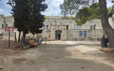 Wejście do Aquarium Pula w austro-węgierskim forcie Verudela, z kamienną fasadą i plakatami akwarium