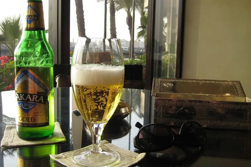 Butelka egipskiego piwa Sakara Gold i pełny kieliszek na stoliku w hotelu w Kairze
