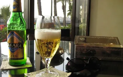 Butelka egipskiego piwa Sakara Gold i pełny kieliszek na stoliku w hotelu w Kairze