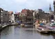 Kanał w centrum Amsterdamu z łodziami wycieczkowymi i ceglanymi kamienicami