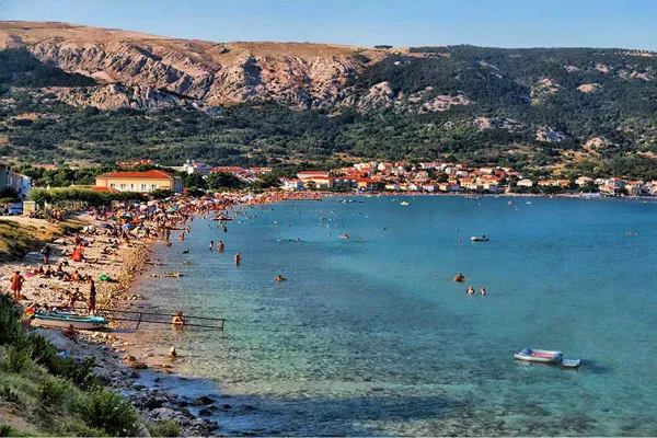 Żwirowa plaża w Bašce z widokiem na miasto i zbocza gór