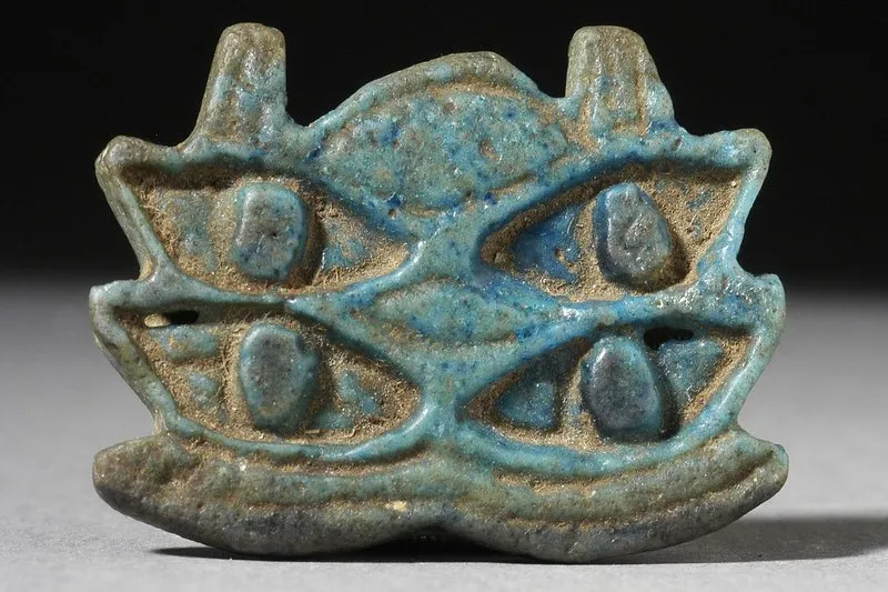 Niebieski fajansowy amulet z czterema stylizowanymi oczami Horusa