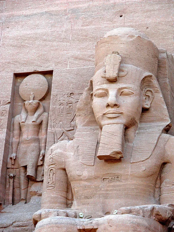 Kolos Ramzesa II obok płaskorzeźby boga Re-Horachte z tarczą słoneczną nad głową w Abu Simbel