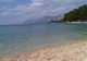 Jasna żwirowa plaża w Breli z przejrzystą wodą i masywem Biokovo w tle