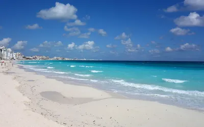 Biała piaszczysta plaża w Cancún i turkusowe morze pod błękitnym niebem
