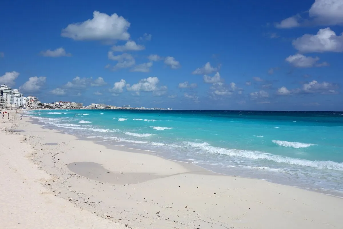 Biała piaszczysta plaża w Cancún i turkusowe morze pod błękitnym niebem
