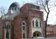 Ceglana fasada Synagogi Chóralnej w Charkowie z ostrołukowymi oknami i ciemną kopułą, przed nią bezlistne drzewa