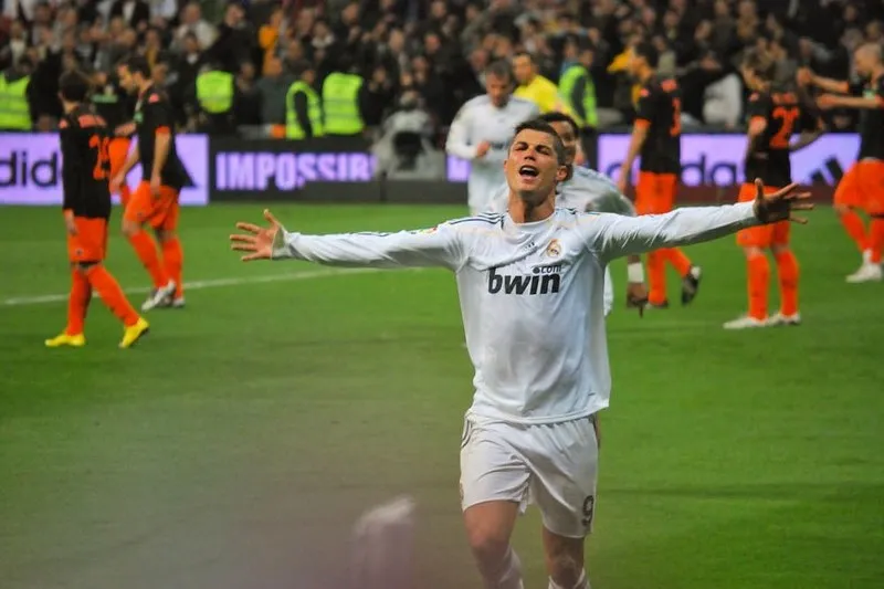 Cristiano Ronaldo w białej koszulce Realu Madryt cieszy się z gola na stadionie