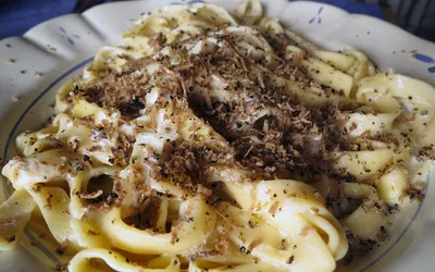 Talerz makaronu fettuccine posypanego startą truflą
