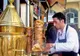 Sprzedawca ulicznego baru nakłada döner kebab z obrotowego rożna do chleba