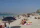Turyści w strojach kąpielowych na zatłoczonej publicznej plaży w Dubaju