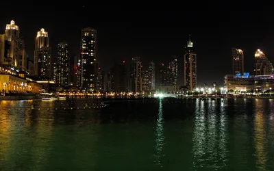 Nocna panorama wieżowców Downtown Dubai odbijających się w wodzie jeziora