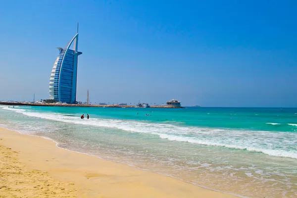 Piaszczysta plaża w Dubaju z widokiem na hotel Burdż al-Arab