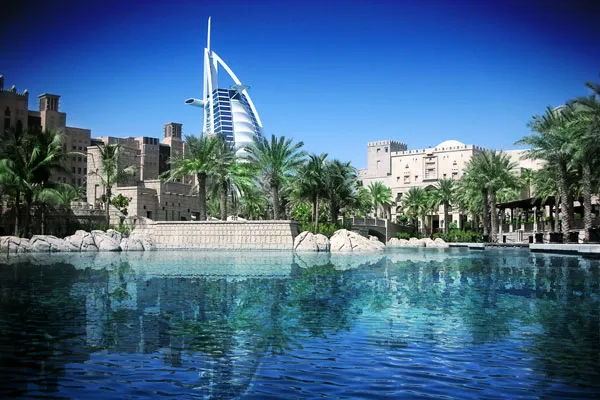 Burdż al-Arab nad wodną laguną i palmami w Dubaju