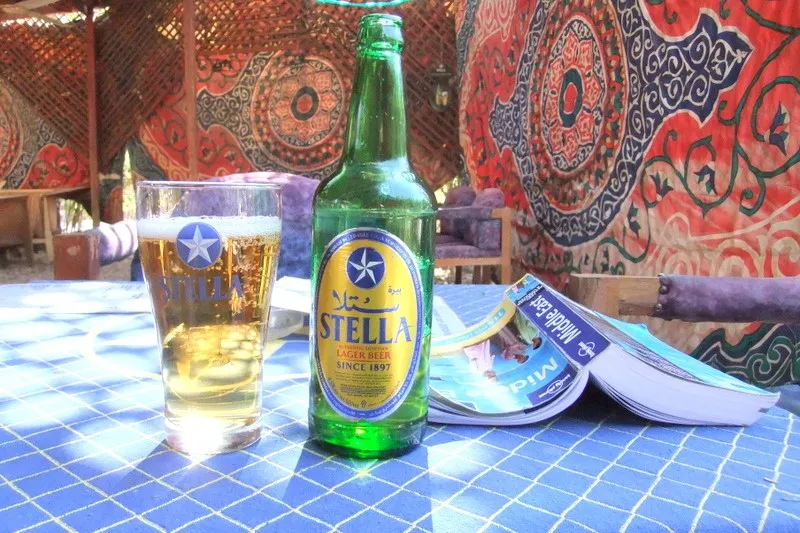 Butelka i szklanka egipskiego piwa Stella na stoliku w kawiarni