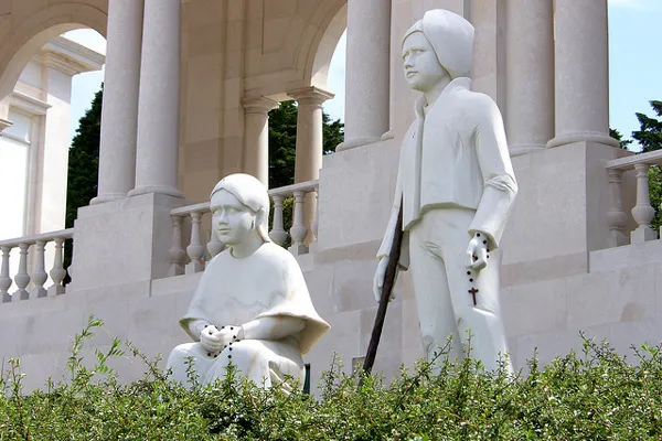 Portugalia | W 1917 r. trójce wiejskich dzieci ukazała się Matka Boska Białe posągi Franciszka i Hiacynty Marto przed kolumnadą sanktuarium w Fatimie