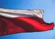 Biało-czerwona flaga Polski łopocząca na tle błękitnego nieba