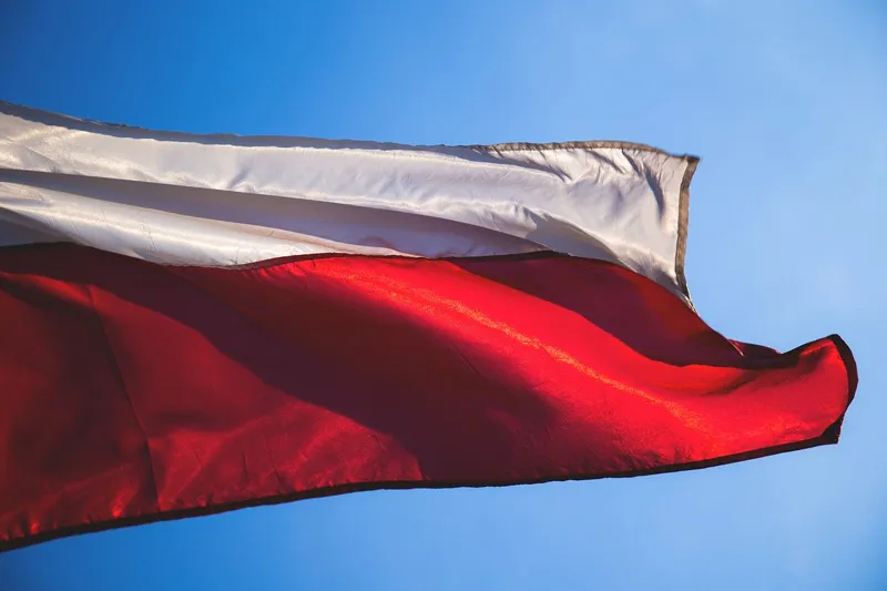 Biało-czerwona flaga Polski łopocząca na tle błękitnego nieba