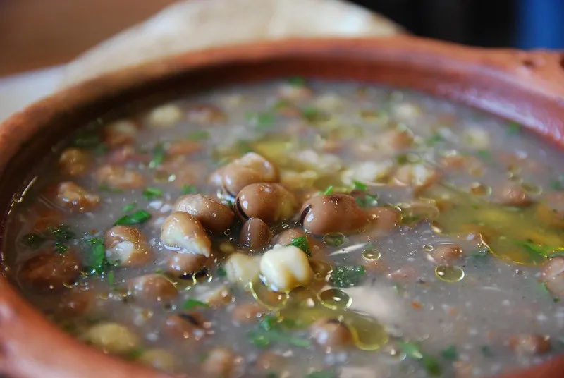 Gęsty ful medames z brązową fasolą, oliwą i natką pietruszki w glinianej misce