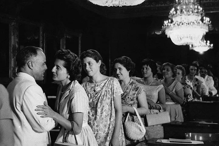 Czarno-białe zdjęcie: Habib Burgiba wita się z elegancko ubranymi kobietami w sali pałacu Bardo, 25 lipca 1957 roku