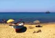 Kolorowa łódź rybacka i parasole na piaszczystej plaży w Hammamecie