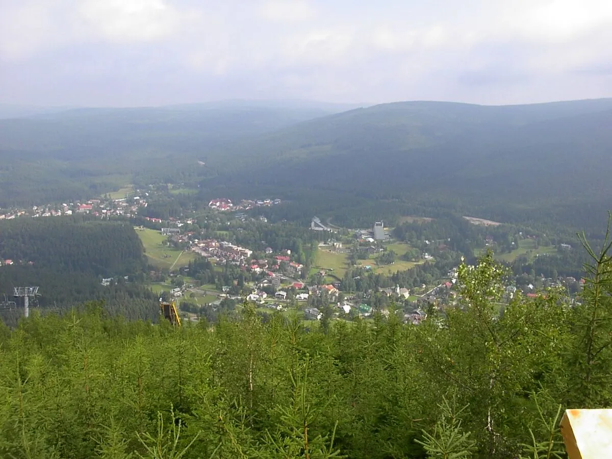 Widok z Čertovej Hory na Harrachov i otaczające go lesiste wzgórza