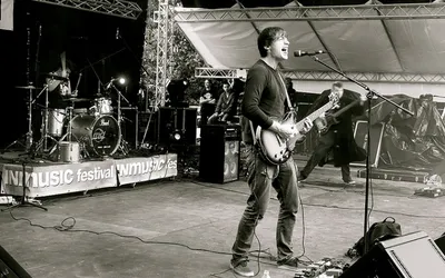 Gitarzysta śpiewający na scenie festiwalu INmusic w Zagrzebiu, zdjęcie czarno-białe