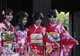 Cztery młode Japonki w czerwonych kimonach furisode z szerokimi pasami obi