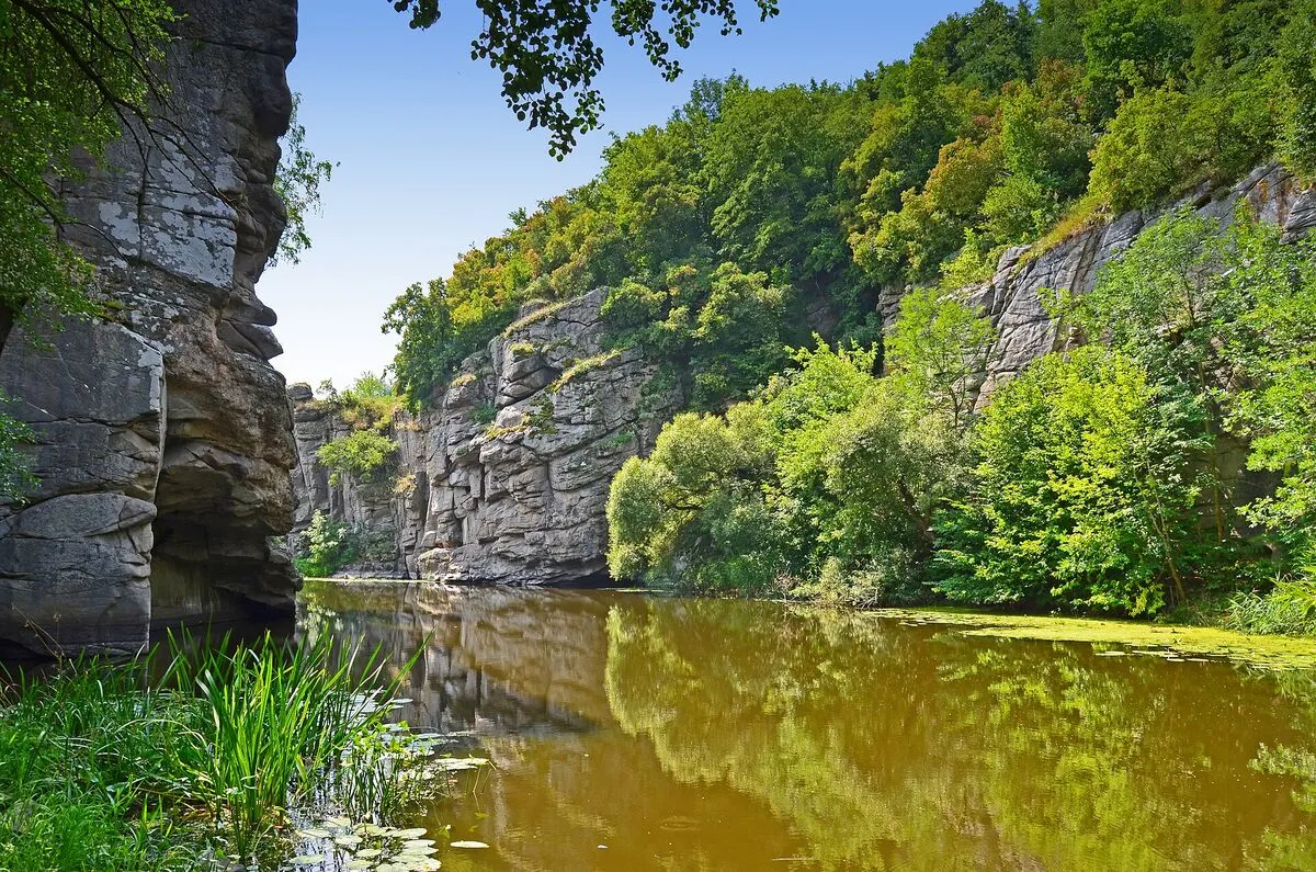 Skalne ściany Kanionu w Bukach nad spokojną rzeką