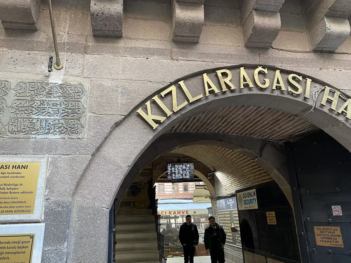 Kamienna brama wejściowa karawanseraju Kızlarağası Hanı w Izmirze ze złotym napisem nad łukiem