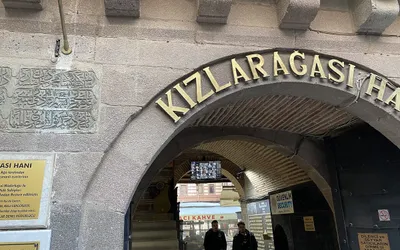 Kamienna brama wejściowa karawanseraju Kızlarağası Hanı w Izmirze ze złotym napisem nad łukiem