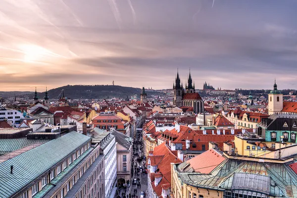 Czerwone dachy Starego Miasta w Pradze z wieżami kościoła Marii Panny przed Tynem o zachodzie słońca