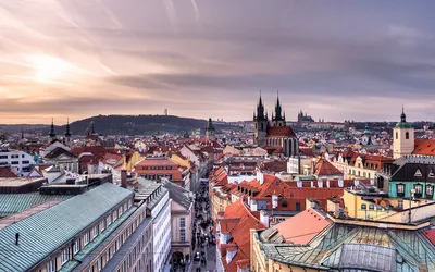 Czerwone dachy Starego Miasta w Pradze z wieżami kościoła Marii Panny przed Tynem o zachodzie słońca