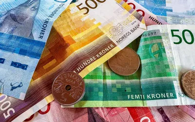 Norweskie banknoty serii Morze i monety koronowe rozłożone na stole