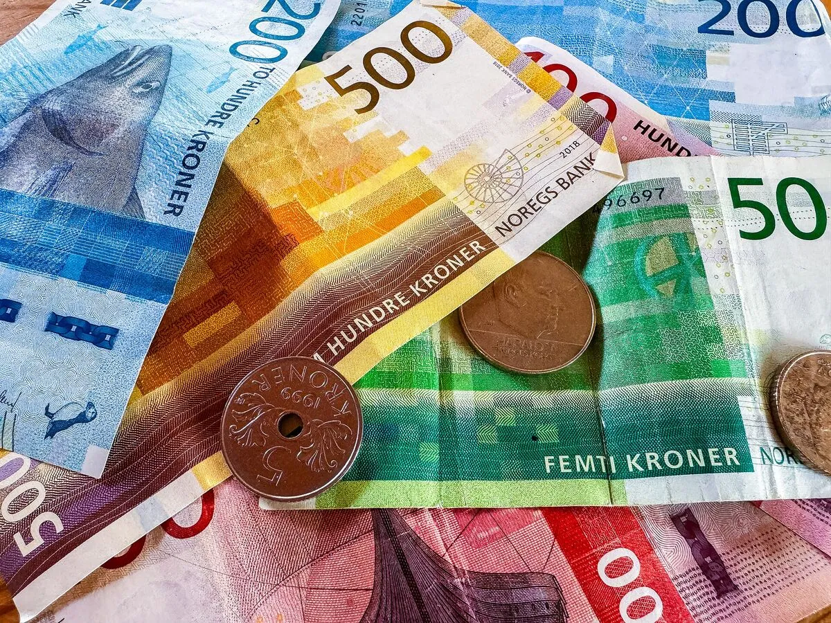 Norweskie banknoty serii Morze i monety koronowe rozłożone na stole