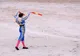 Torero z czerwoną muletą przed szarżującym bykiem na arenie