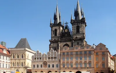 Gotyckie wieże kościoła Marii Panny przed Tynem nad kamienicami Rynku Staromiejskiego w Pradze, na placu tłum turystów