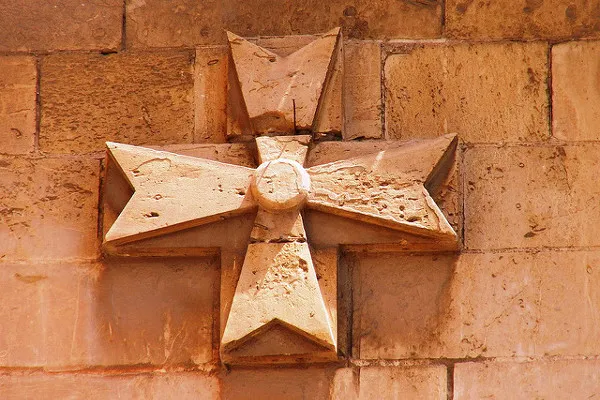 Jeden z wielu krzyży maltańskich na murach kamienicy