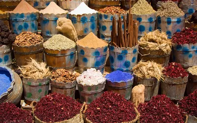 Beczułki z przyprawami, laskami cynamonu i suszonym hibiskusem na bazarze w Hurghadzie