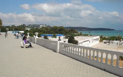 Biała balustrada nadmorskiej promenady w La Marsa, w tle zatoka i wzgórza pod Tunisem