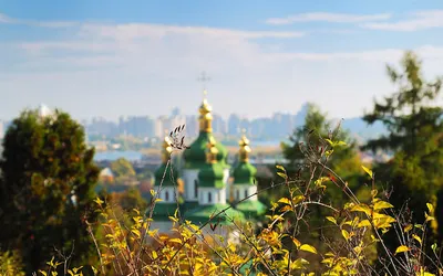 Zielone kopuły cerkwi nad Dnieprem na tle panoramy Kijowa jesienią