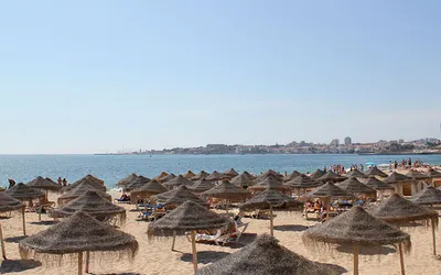Słomkowe parasole i leżaki na plaży w Estoril pod Lizboną
