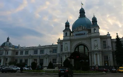 Gmach dworca Lwów Główny z kopułą i napisem „Вокзал” o zmierzchu