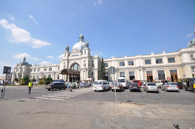 Fasada dworca Lwów Główny z kopułą i parkingiem przed budynkiem