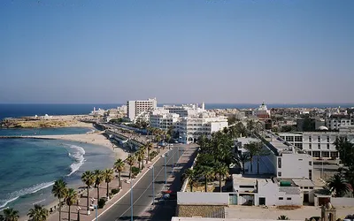 Nadmorska promenada z palmami, plaża i białe hotele w Al-Mahdiji