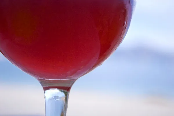 Kieliszek czerwonego wina lub sangrii na rozmytym tle morza