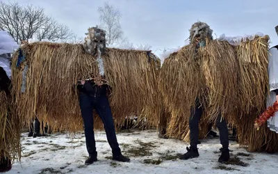 Dwa słomiane stwory w maskach podczas Malanki w skansenie w Czerniowcach
