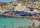 Tłum plażowiczów i niebieskie parasole nad Błękitną Laguną na Comino
